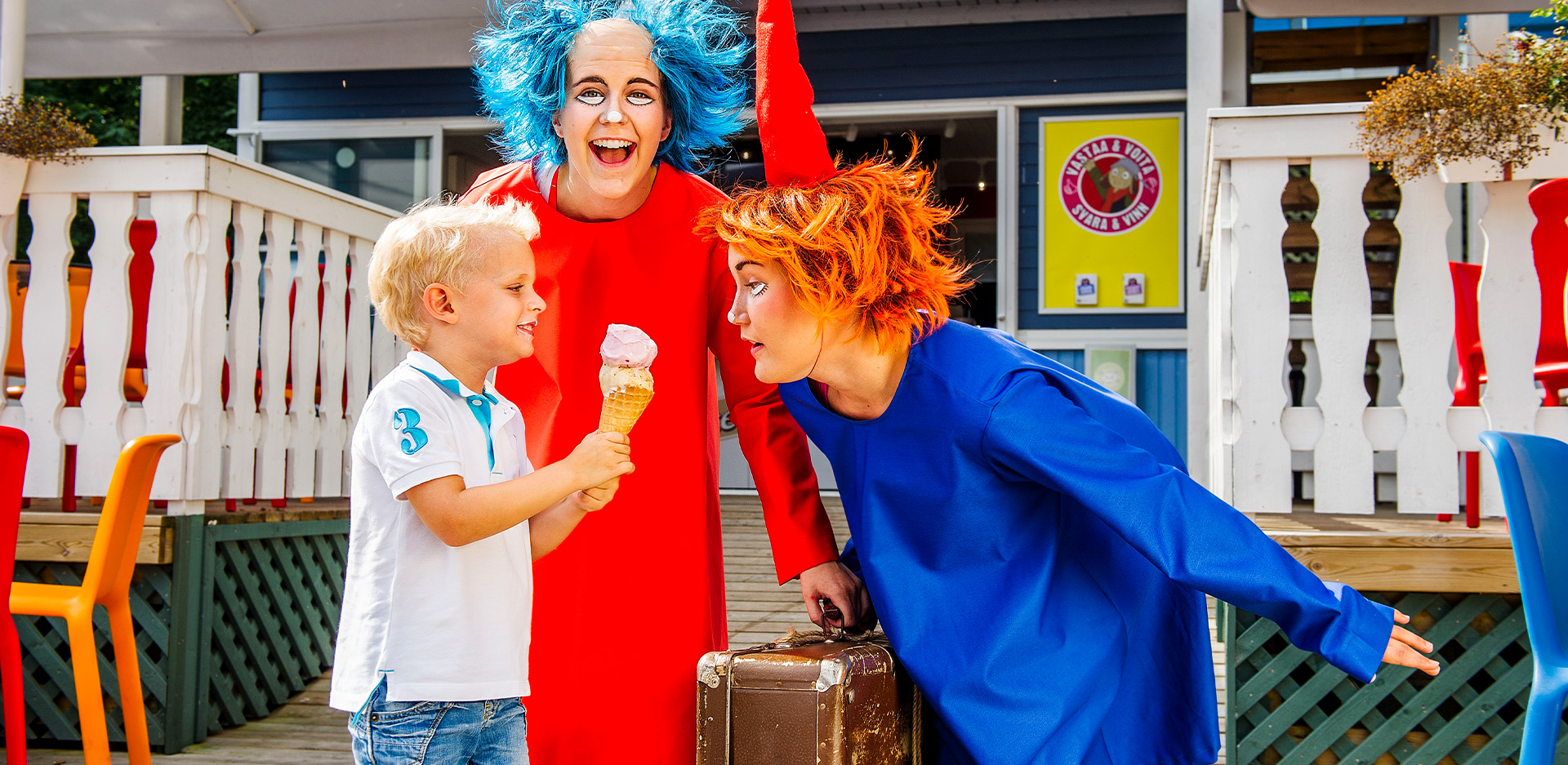 Tiuhti ja Viuhti syövät jäätelöä Tiuhdin ja Viuhdin jäätelöbaarin edessä.