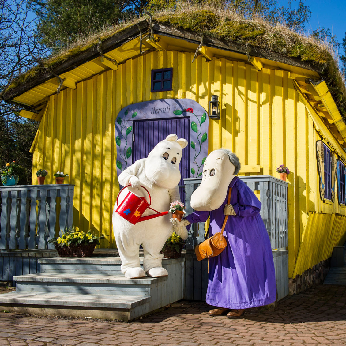 Moomintroll and Hemules in the front of the Hemule's House